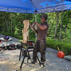 the mindful carver holding a chainsaw working on a standing bear